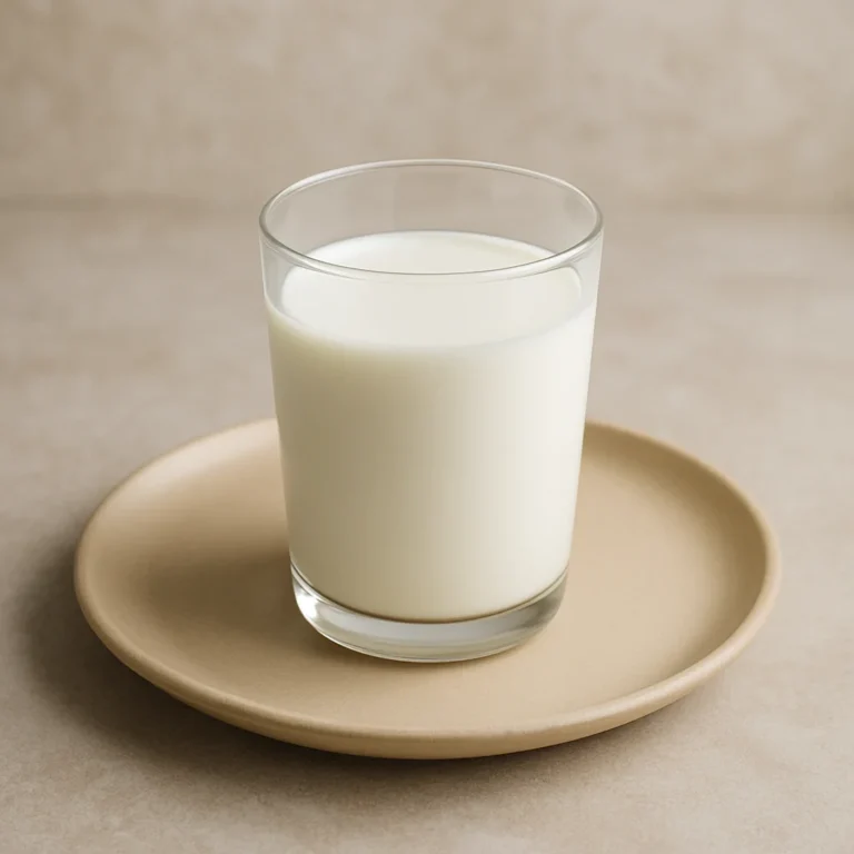 유리컵에 담긴 우유가 접시에 놓인 모습